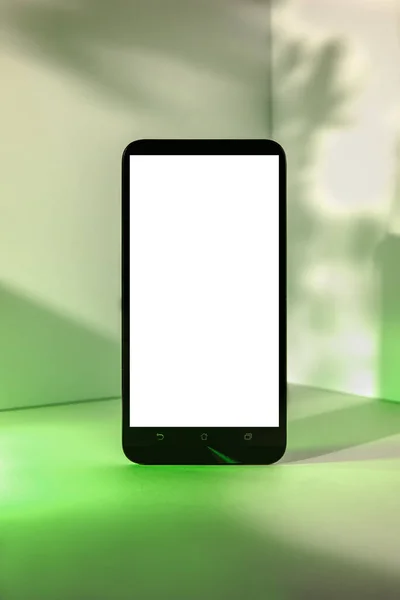 Minimalist modern smartphone mockup for presentation, in perspective front of the corner angle of the wall, with green abstract and plant shapes on background. application display, information or graphics