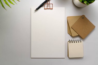Boş şirket kimlik kırtasiyesi seti, kişisel markalaşma şablonu. Kağıtlar, dolmakalem ve ofis malzemeleri, açık arkaplanda yeşil bitkilerle süslenmiş.