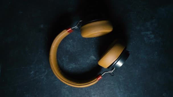 Les écouteurs avec des mouvements de lumière et de lumière projettent différentes ombres et lumières, sur un fond sombre, changeant les textures et le volume. Musique et concept sonore