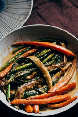 Kremayla sotelenmiş sebzeler. Tavada sotelenmiş, masada yemek için hazır. Sağlıklı yeme kavramı
