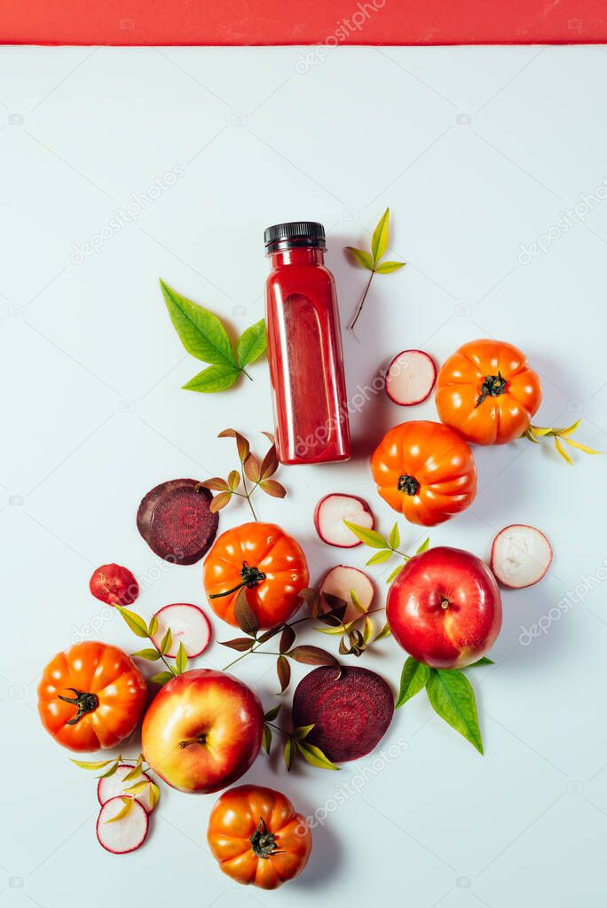 Red smoothie drink in bottle near ripe apples tomatoes and beets. Detox diet for healthy body and mind. health food concept