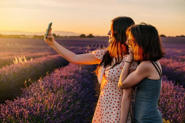 Két Barát Szórakozik Fotóznak Mobiltelefonjukkal Virágzó Levendulák Mezején Naplementekor Nyaralás — Stock Fotó