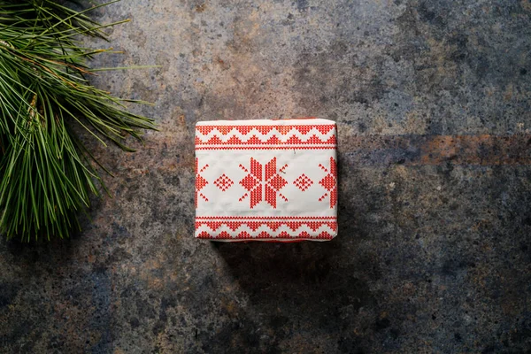 圣诞礼品盒 用喜庆纸包着 周围环绕着松枝 背景是深蓝色的 圣诞节在家里的概念 — 图库照片