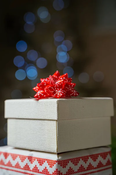 Stacked Christmas Presents Wrapped Festive Paper Adorned Red Bow Defocused — Stock Photo, Image