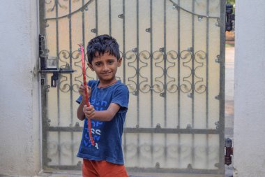 Indian kid playing with his bow and arrow in his school holidays