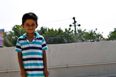 Indian kid posing for a perfect picture under hot sunlight