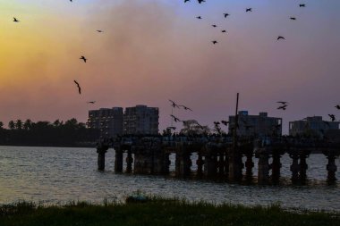 Güzel günbatımında suyun altındaki antik bir yerin resmi.