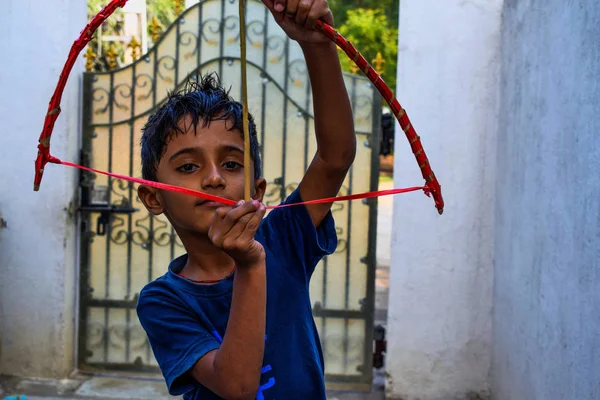 Miúdo indiano brincando com seu arco e flecha em casa — Fotografia de Stock