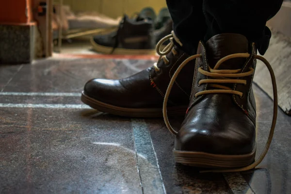 men brown boots with brown laces posing for the perfect picture