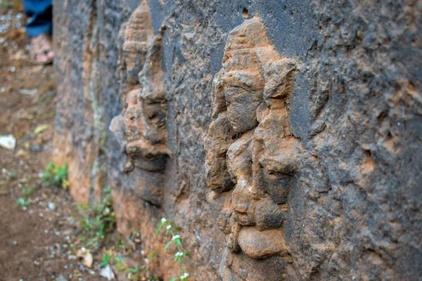 Fotografia Starożytnego zrujnowana rzeźba archeologiczna hinduskiego boga wygrawerowana na szarej kamiennej ścianie. Zdjęcie zrobione w słoneczny dzień w Kolhapur, Maharashtra, Indie. skupienie się na przedmiocie. — Zdjęcie stockowe