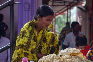 Yadgir, Karnataka / Hindistan - 25 Aralık 2019; Yaşlı Hintli kadınlar pazar alanında geleneksel abur cubur satıyor