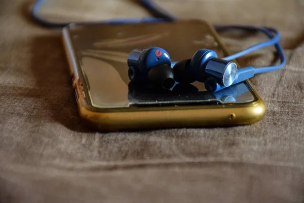 Nahaufnahme Von Blauem Ohrhörer Mit Smartphone — Stockfoto