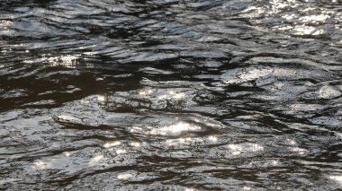 Parlak ve güzel doku ve dinamik desenler oluşturma güneşli bir günde, dalgalı nehir yüzeyinde parıldayan güzel güneş yumuşak odaklı parlama