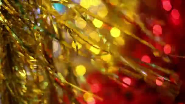 クリスマスおよび新年の休日のお祝い ゴールド クリスマスの見掛け倒し花輪飾りが風に吹かれて バック グラウンドで点滅ぼやけのクリスマス ライト — ストック動画