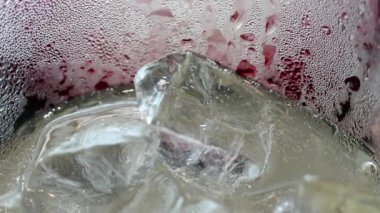 İçki Ayrıntılar soyut güzelliği. Buzlu erik suyu gazoz aşırı yakın çekim bardakta içerim. Su damlaları cam yüzeyi oluşturur güzel doku desenleri.