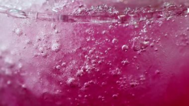 İçki Ayrıntılar soyut güzelliği. Aşırı kırmızı buzlu soda close-up bardakta içerim. Ezilmiş buz ve gazlı kabarcıklar güzel doku desenleri oluşturmak.