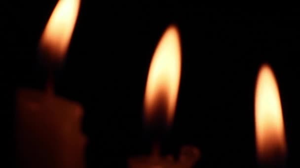 Close Van Wazige Brandende Kaarsen Vlammen Die Nachts Wind Zwaaien — Stockvideo