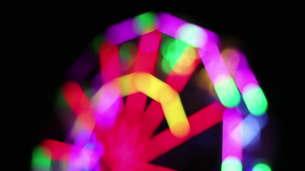 Grande roue déconcentrée avec la décoration colorée d'éclairage de lampe fluorescente tourne lentement à la foire d'amusement de nuit .