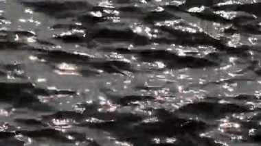 Yumuşak odak güzel güneş parıldıyor ve güneşli bir günde dalgalı deniz yüzeyinde parıldıyor. Güzel bir doku ve dinamik desenler yaratıyor..