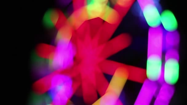 蛍光灯のカラフルな装飾が施されたフェリスホイールは 夜の楽しいフェアでゆっくりと回転します — ストック動画