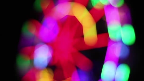 Grande roue déconcentrée avec la décoration colorée d'éclairage de lampe fluorescente tourne lentement à la foire d'amusement de nuit .