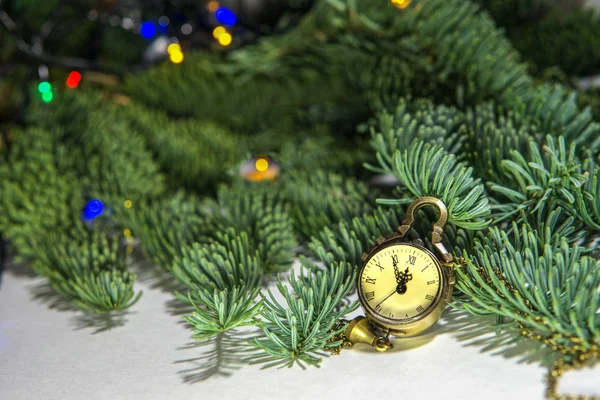 New Year\'s Eve, the clock - the medallion shows 23.55. Soon a new time. on the background of a green Christmas tree. waiting for a miracle. new life, plans, desires.