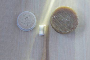 Beyaz havlu ve doğal ışık üstten görünüm altında hafif ahşap arka plan bambu diş fırçası yatıyor