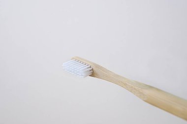 doğal bambu diş fırçası ile ahşap sapı ve doğal ışık altında beyaz arka plan üzerinde beyaz kıllar