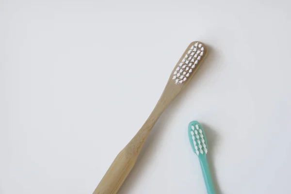 Natural bamboo toothbrush versus plastic blue brush — Stock Photo, Image