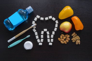oral kavite - bir şişe gargara, diş plastik ve bambu ekoloji fırça ve diş ipi ve siyah bir zemin üzerine diş korumak için doğru gıdalar yeme bakımı için ayarla