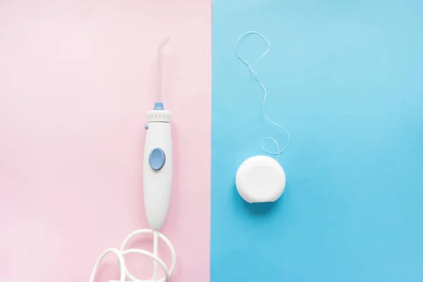 Oral irrigator versus floss top view on pink and blue background — Stock Photo, Image