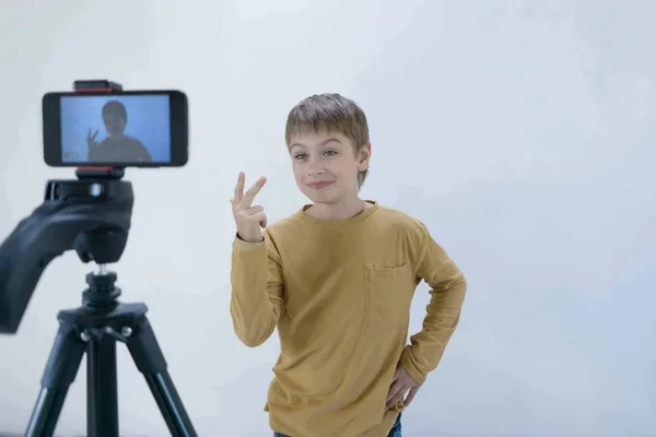Schoolboy generation Milenium stands at the concrete wall in his house and shoots video for his channel to put on the Internet with space for text — Stock Photo, Image