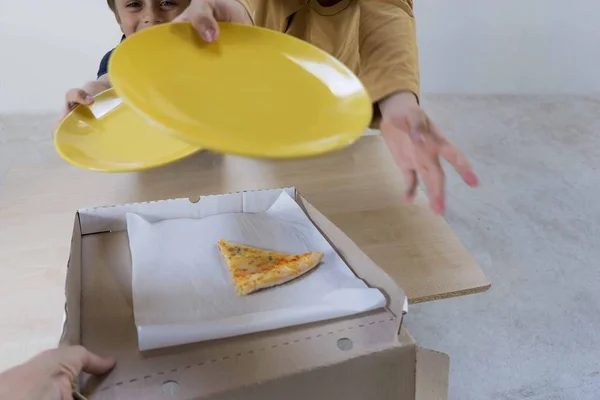 Дітей просять дати їм останній шматок піци 4 сири, що залишилися в коробці після сімейної вечері — стокове фото