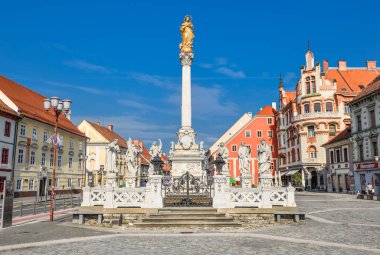 Maribor, Slovenia - May 22, 2018: Main square building and plague column in Maribor city, Slovenia, Europe. Historical religious sculpture and one of the best examples of baroque art in Slovenia clipart