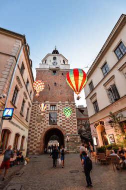 Lublin, Polonya - 10 Ağustos 2017: güzel bir akşam street, balonlar ve eski parlak binalar Lublin, Polonya'nın eski şehir parlıyor. Brama street, Lublin. Mountebanks karnaval Lublin eski şehirde.