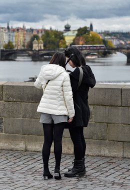 Prague, Çek Cumhuriyeti - 10 Ekim 2017: iki güzel Asyalı kızlar çekici selfie ve görünüm Prag eski şehir ve Vltava Nehri