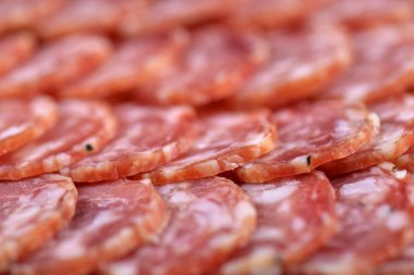 Salam sosis dilimleri arka plan. Yakın çekim. Tütsülenmiş sosis dilimleri. Gıda arka plan. Merkezi odak.