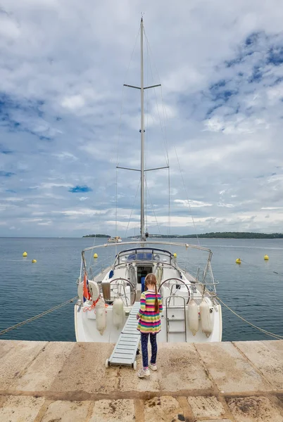 Маленькие девочки перед яхтой на пирсе прибрежного города Ровинь, Истрия, Хорватия . — стоковое фото