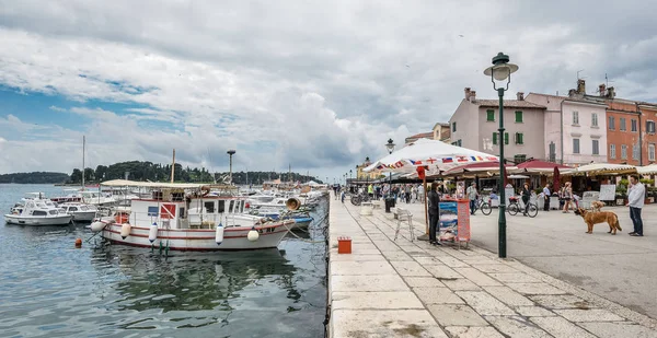 Menschen zu Fuß in der Nähe von Pier und Yachten in der Küstenstadt Rovinj, Istrien, Kroatien. Rovinj - schöne antike Stadt, Yachten und Adria. — Stockfoto