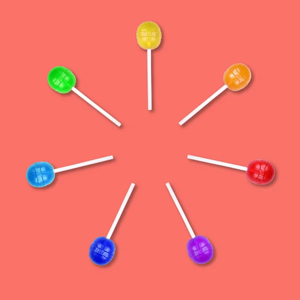 Set van kleurrijke Lollipops gegroepeerd in een cirkel geïsoleerd op koraal achtergrond. — Stockfoto