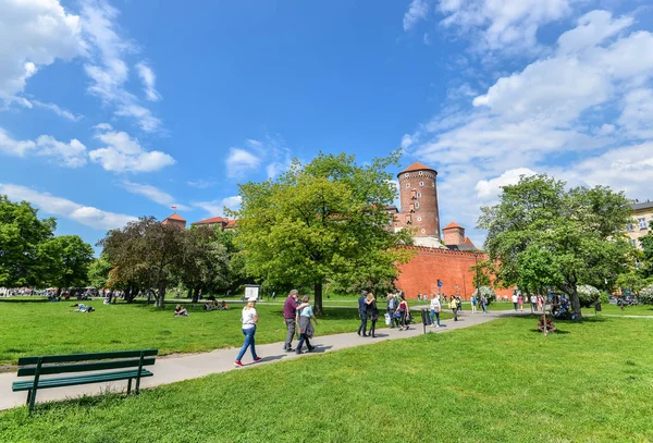 Vew na parede circundante e torre do Castelo Wawel, parque de primavera e turistas ambulantes — Fotografia de Stock