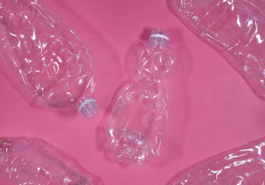 Plastik şişeler pembe arka plan üzerinde izole. Atık yönetimi konseptini geri dönüştür.