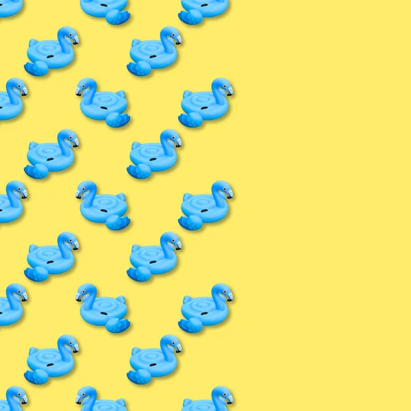 Синий узор фламинго на желтом фоне. Плавательная игрушка в форме голубого фламинго безseamless узор. Надувной фламинго вырезан. Вид сверху, плоский. Копирование пространства . — стоковое фото