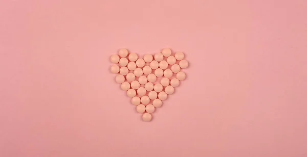 World Heart Day concept. Medical background. Pink Pills in form of heart on pink background. Flat lay. Heart health concept. — 스톡 사진