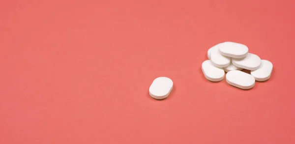 医学的背景。明るいピンクの背景に白い錠剤のスタック — ストック写真