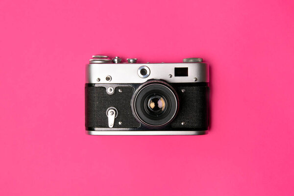Ретро камера изолирована на ярко-розовом фоне. Концепция поп-арта Квартира лежала в минимальном стиле
