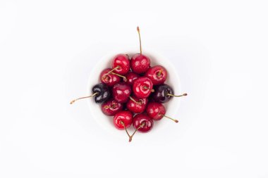 Beyaz kasedeki kırmızı kirazlar beyaza izole edilmiş. Kiraz yakın çekim. Yaz meyveleri