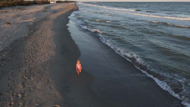 Ein Kleines Mädchen Rosafarbenen Badeanzug Läuft Einem Einsamen Strand Der — Stockvideo