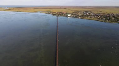 Büyük bir göl veya nehir üzerinde uzun dar bir köprü. Drone görünümü