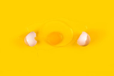 Kırık çiğ yumurta sarı arka planda izole edilmiş. Kırık yumurta ve beyaz kabuk